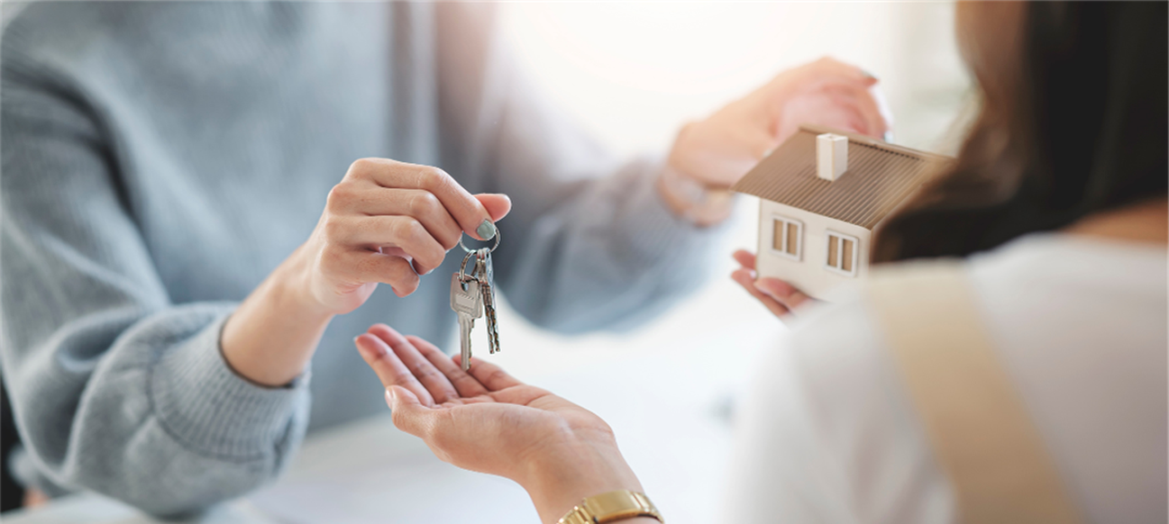 Photo of Title Closing where two people exchange keys for a house